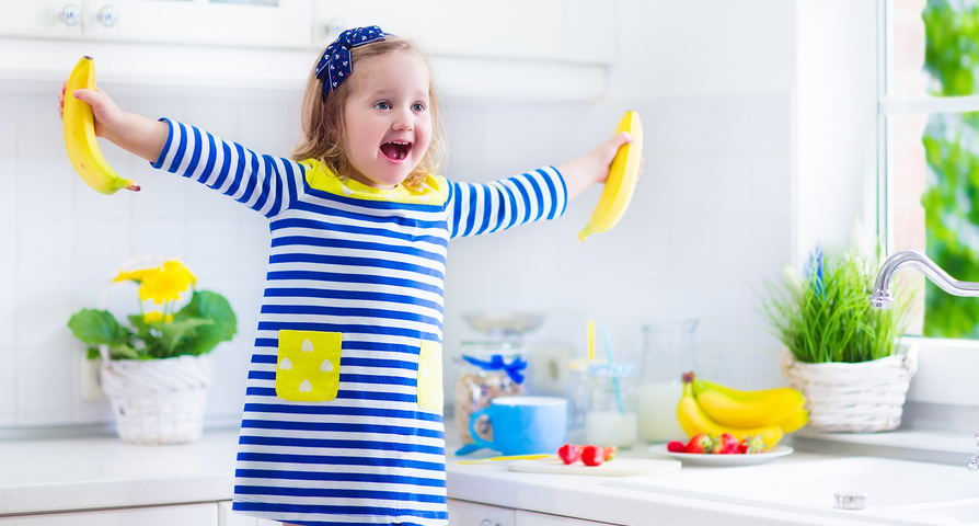 Little Girl Preparing Breakfast In A White Kitchen