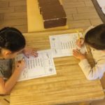 Children working in Language area to practice reading comprehension and practice writing skills