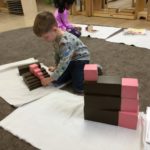 Child working with Brown Stairs and Pink Tower combination using their own imagination for creation of various structures